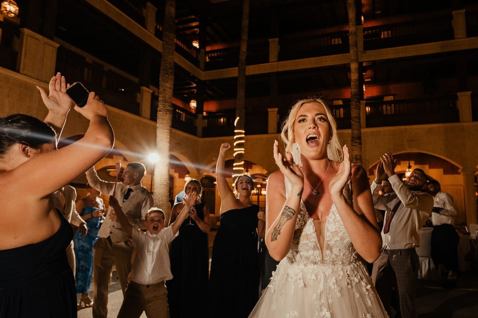 Bride reacting with delight to a singing waiters performance at a wedding abroad