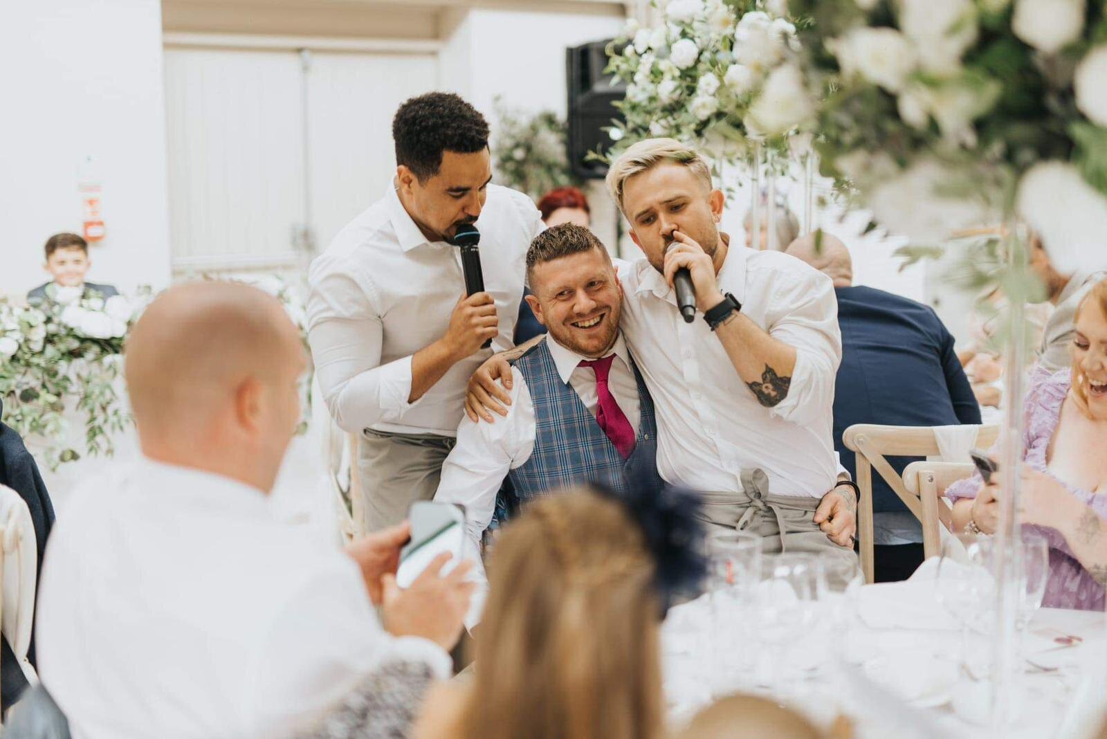 Singing waiters performing among wedding guests in a marquee