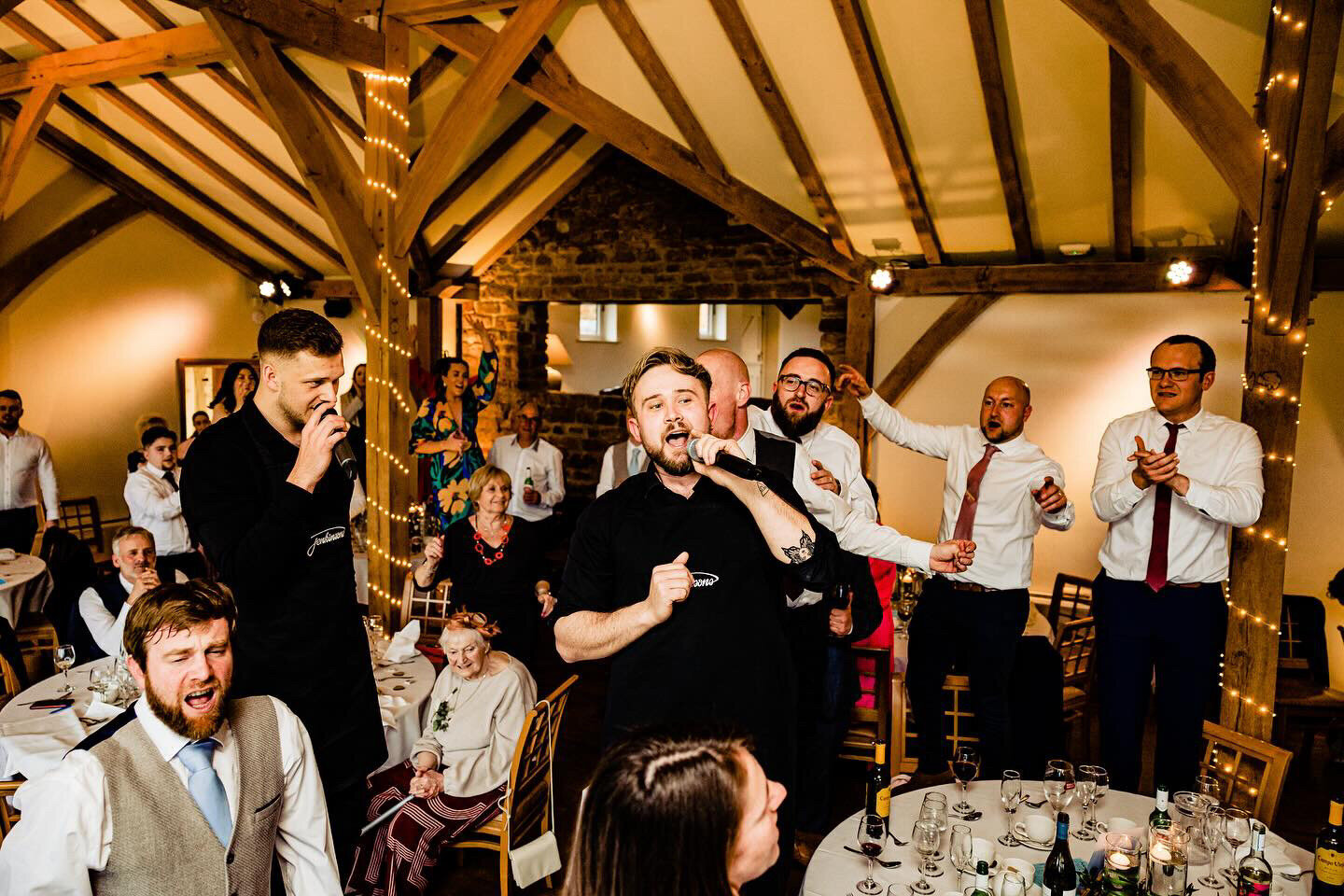 Singing waiters on the balcony of a barn wedding venue