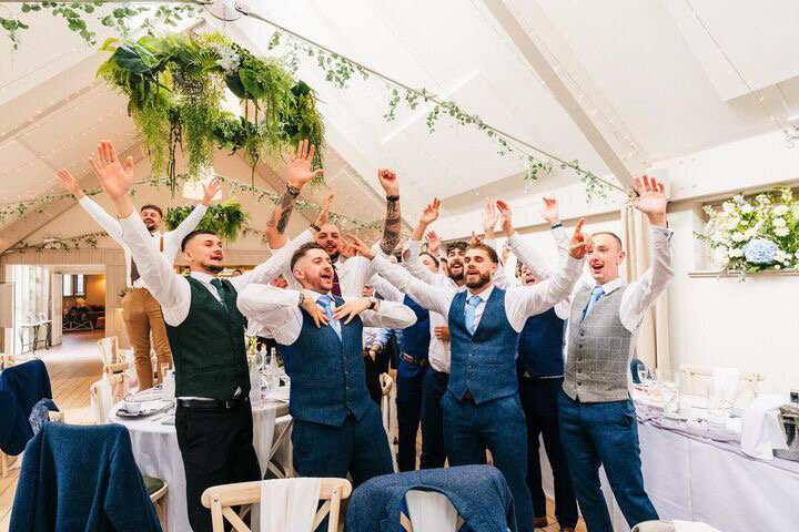 Groomsmen dancing with the singing waiters