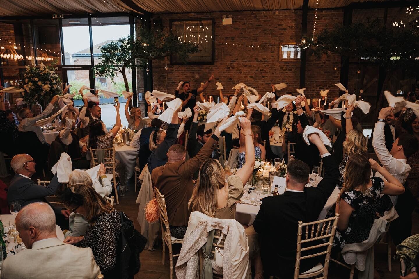 Wedding guests waving napkins as the singing waiters perform