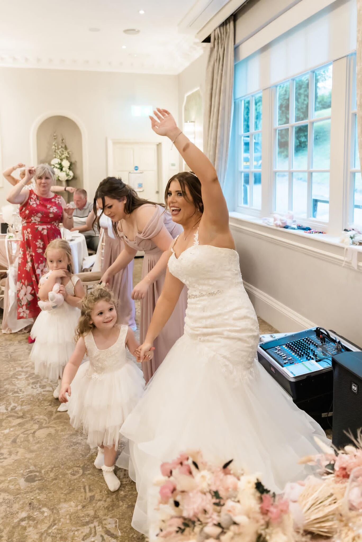 Bride and flower girl dancing to the singing waiters