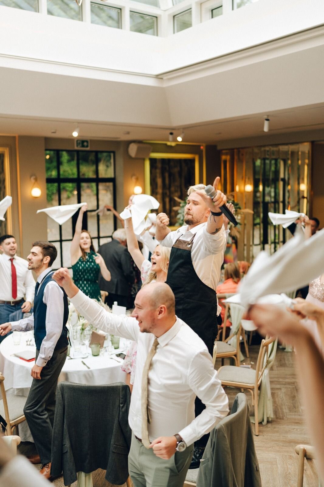 Singing waiters performing at a wedding with a glass roof