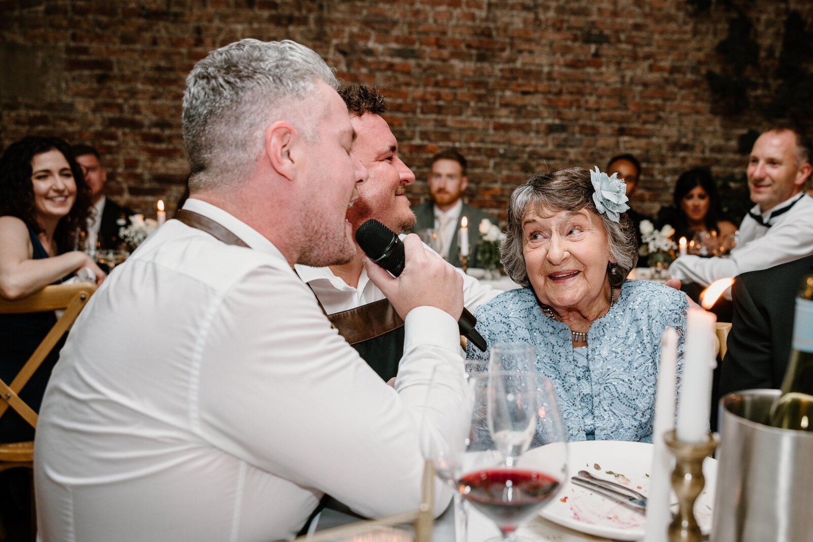 Singing waiter serenading an older guest at a wedding