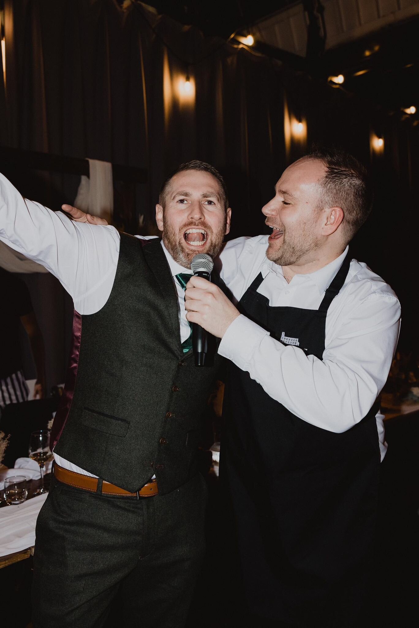 Two singing waiters performing a duet at an evening wedding