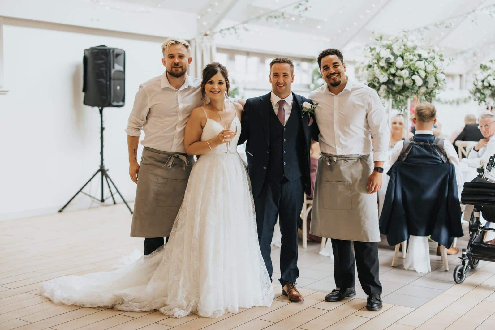 Singing waiters with a bride and groom in a wedding orangery