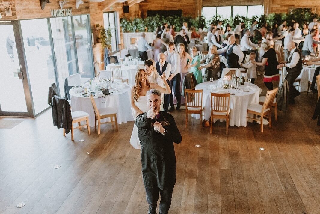 Singing waiter performing to wedding guests in a barn reception
