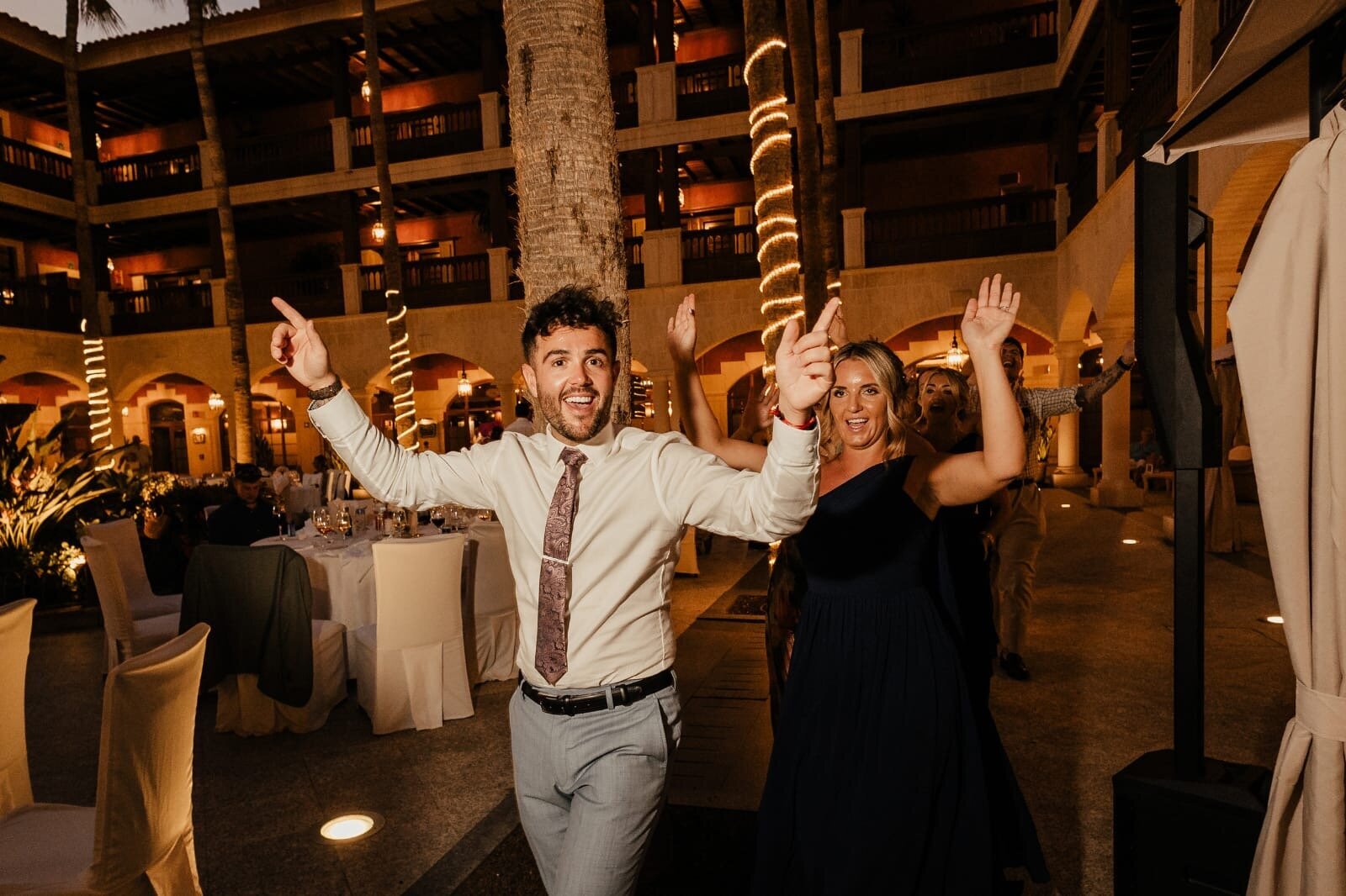 Singing waiter dancing with guests at a destination wedding