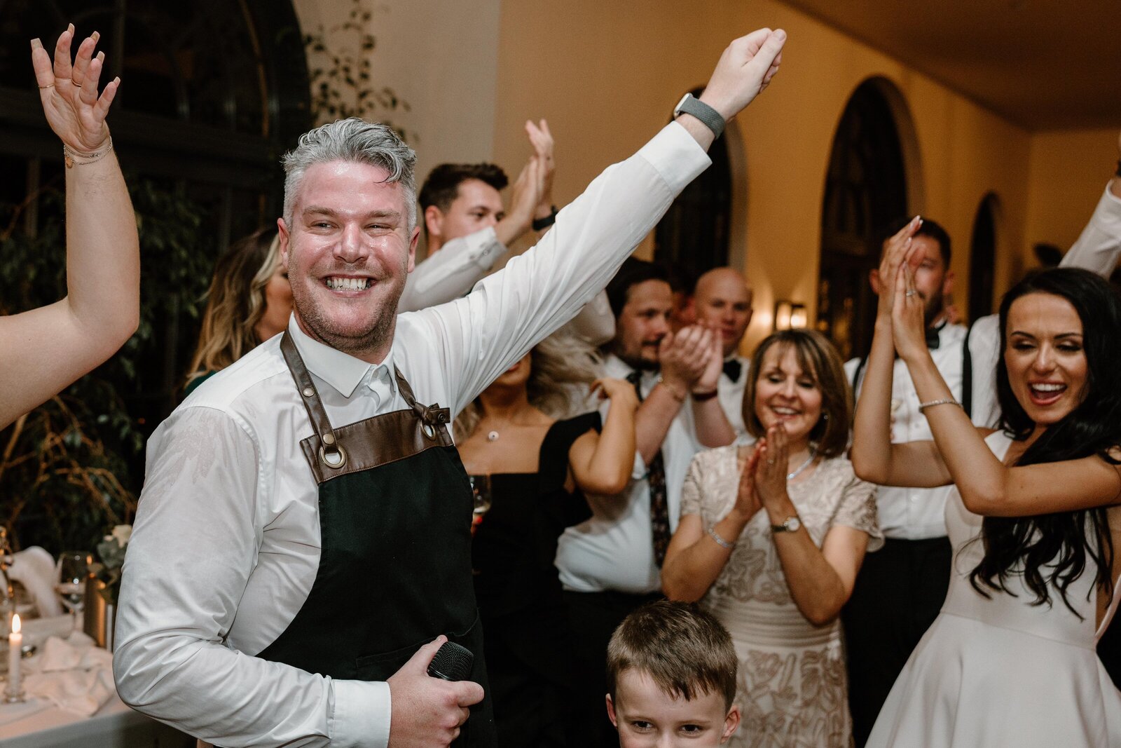 Singing waiter celebrating with guests at a wedding reception