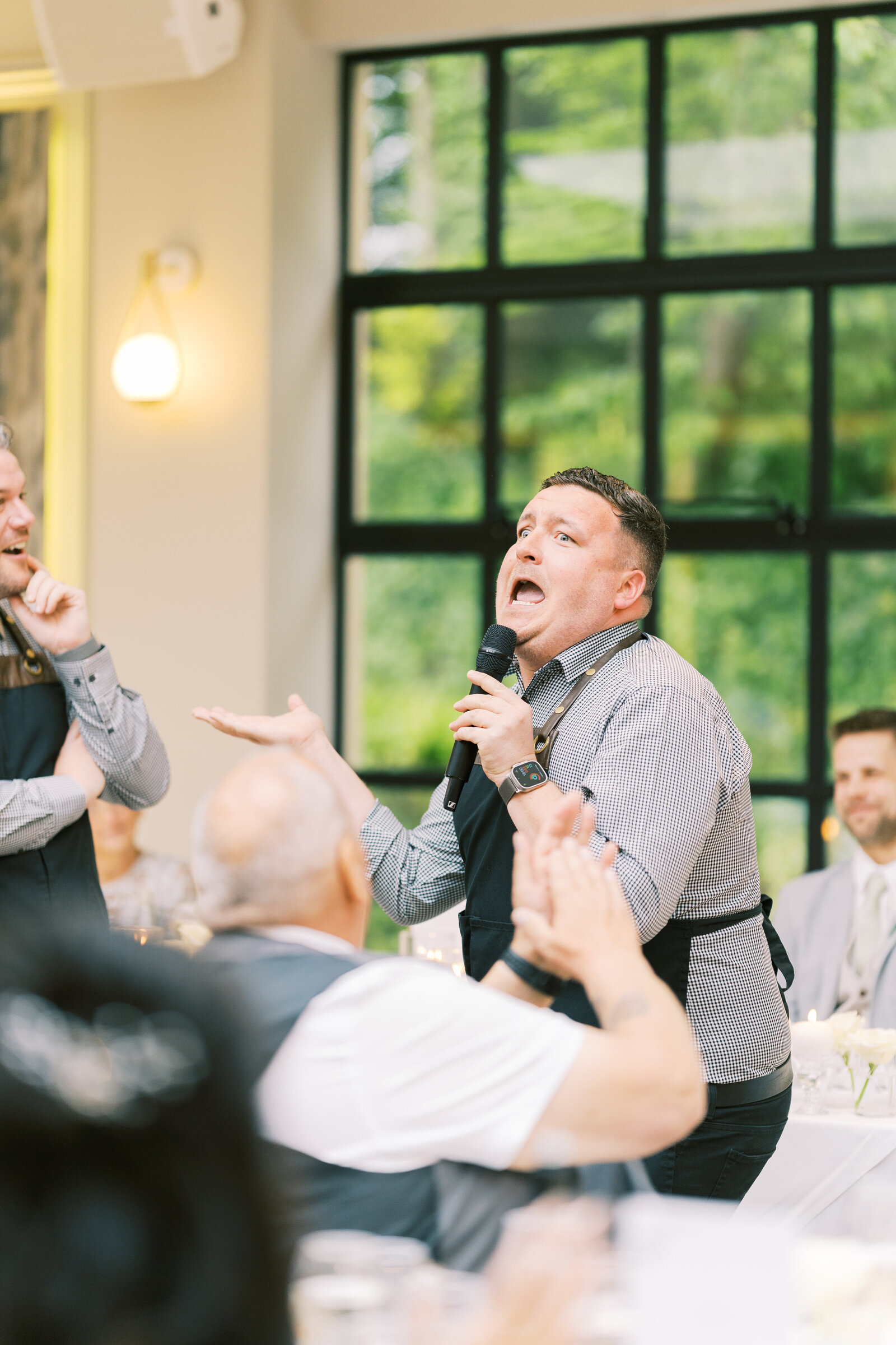 Singing waiter performing to a table of wedding guests