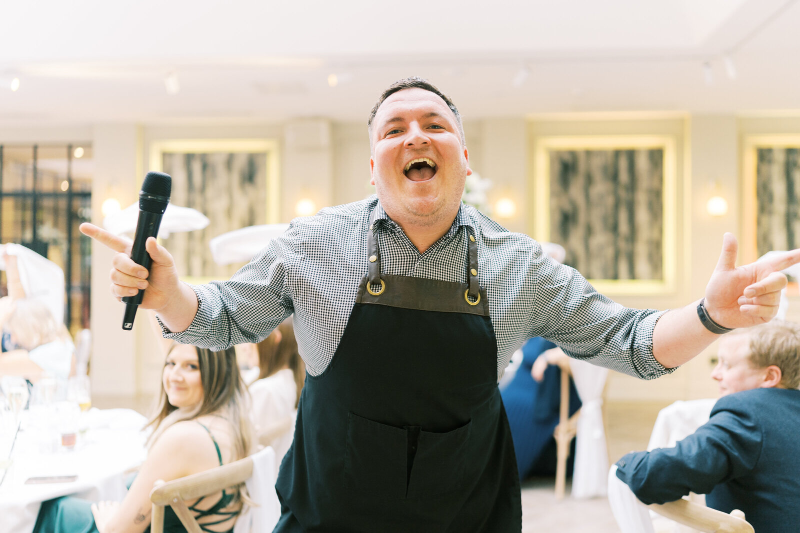 Smiling singing waiter performing to wedding guests