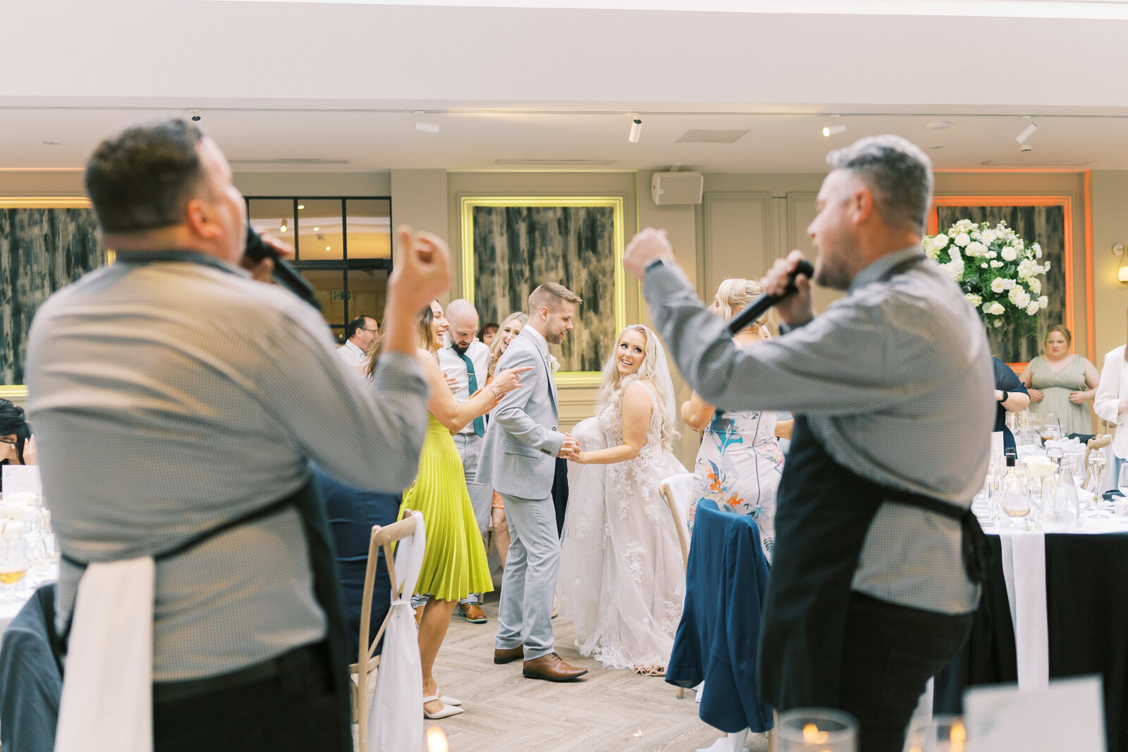 Singing waiters dancing with guests at a wedding reception