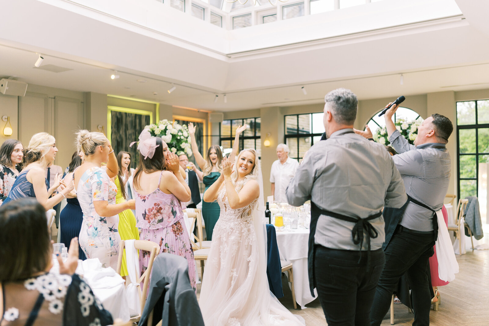 Singing waiters and wedding guests dancing in an orangery