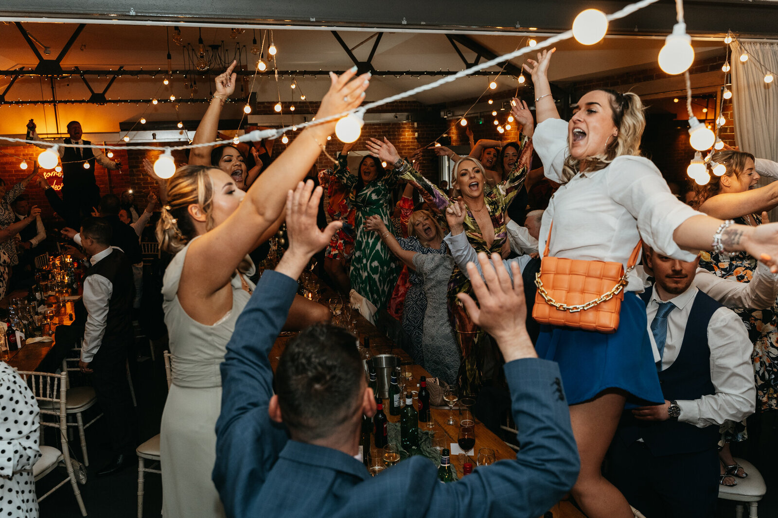 Guests on their feet singing along at a lively evening reception
