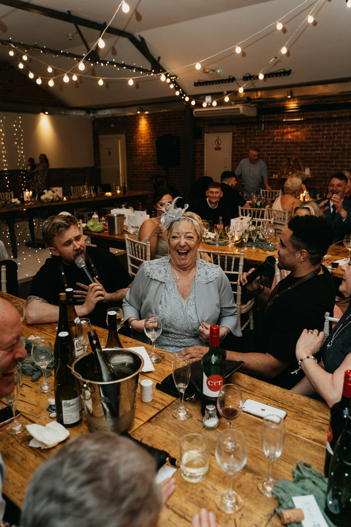 Guests at a table enjoying a singing waiters performance
