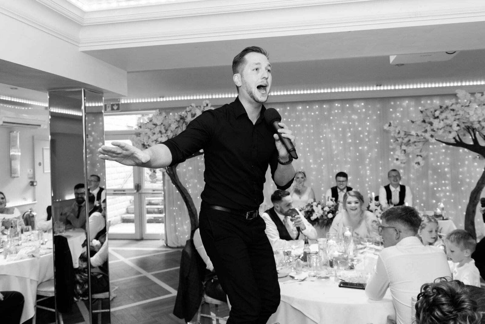 Singing waiter dancing mid-performance, black and white