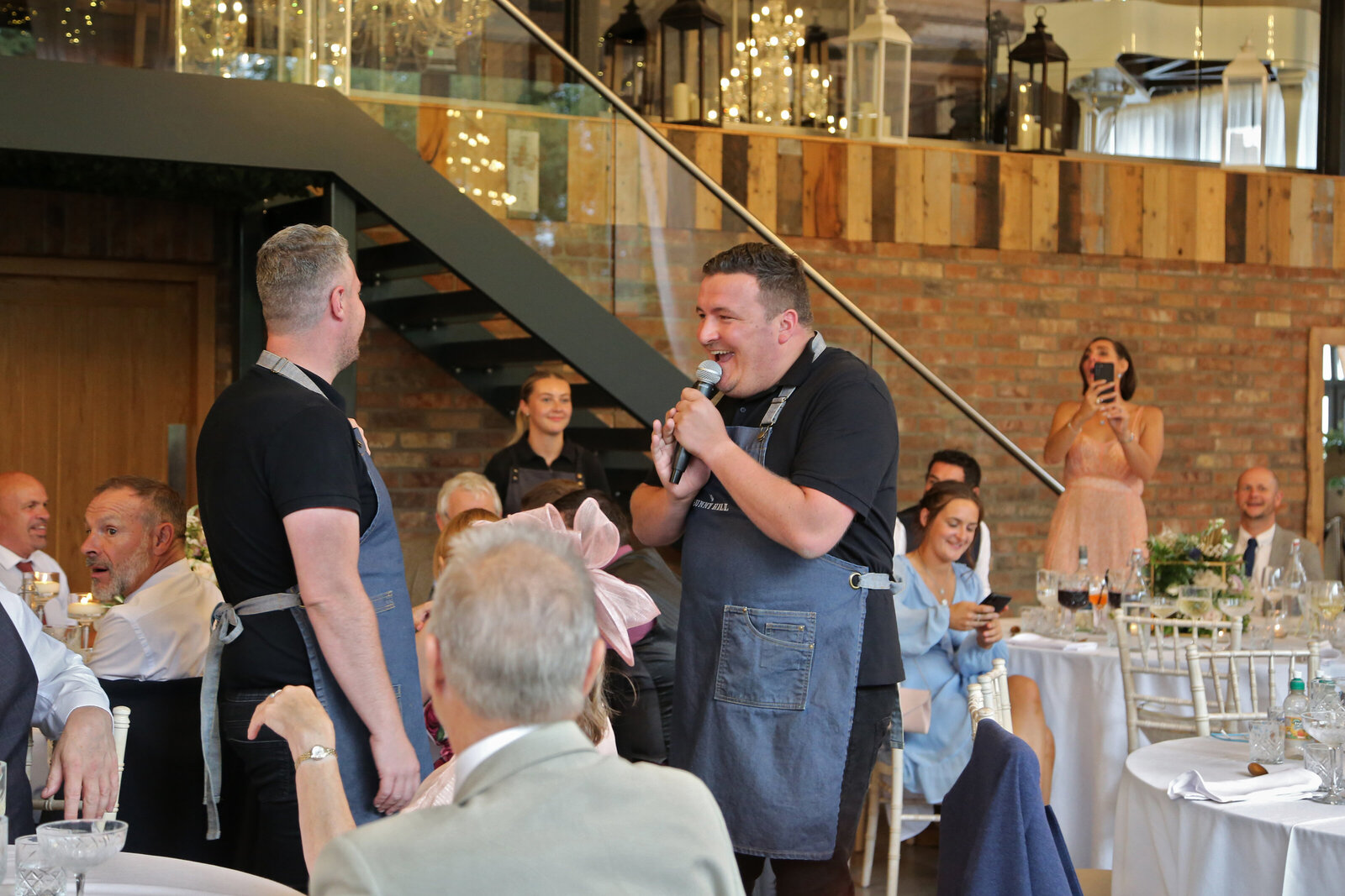 Singing waiters performing beneath a mezzanine at a wedding venue