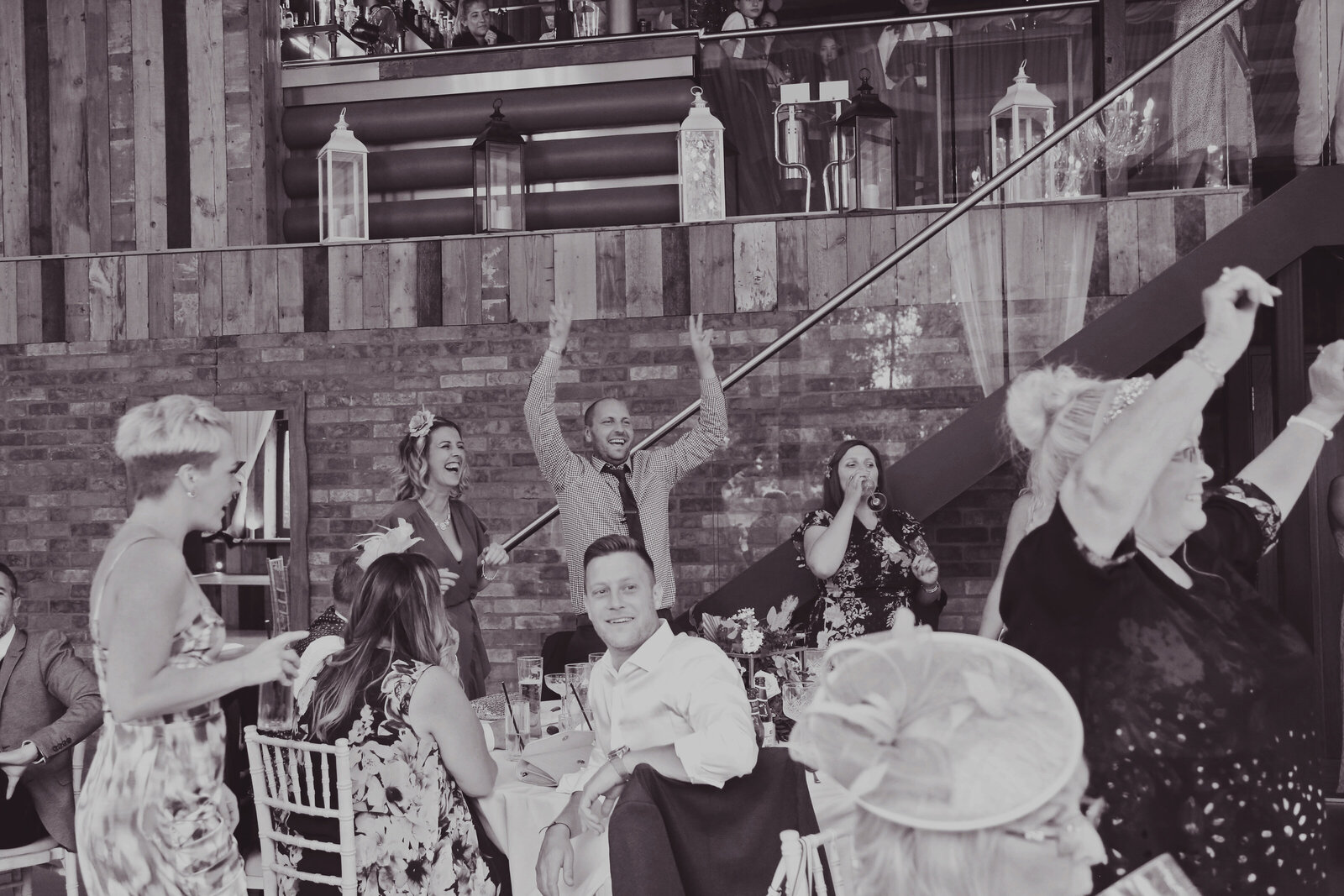 Guests waving napkins in the air at a wedding, black and white