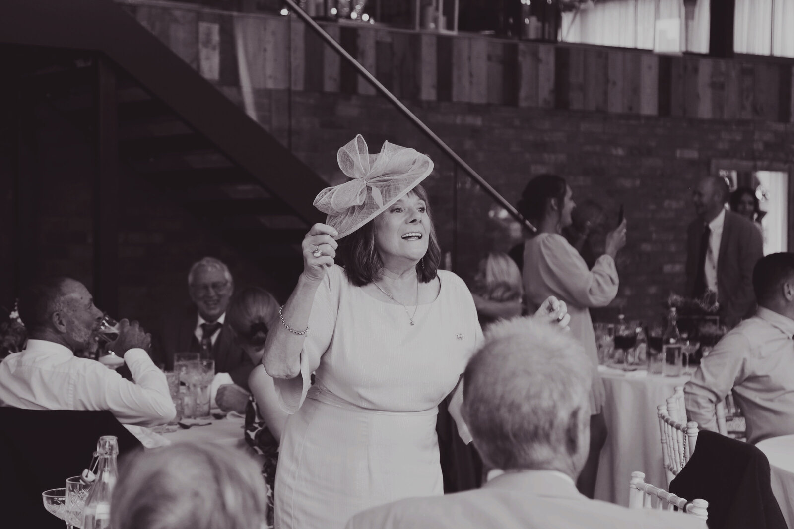 Guest in a hat dancing to the singing waiters, black and white