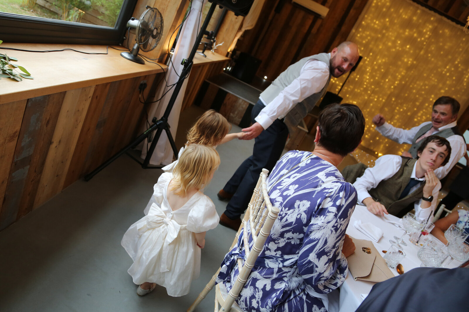 Young guest dancing with a singing waiter at a wedding