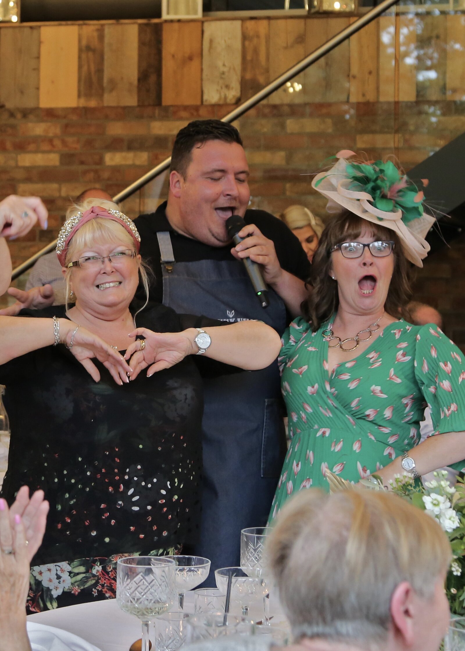 Singing waiter performing with delighted guests at a wedding