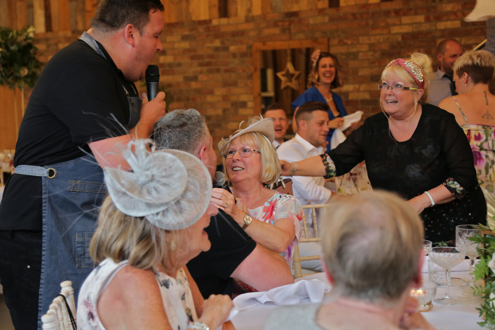 Singing waiter surprising laughing guests at a wedding