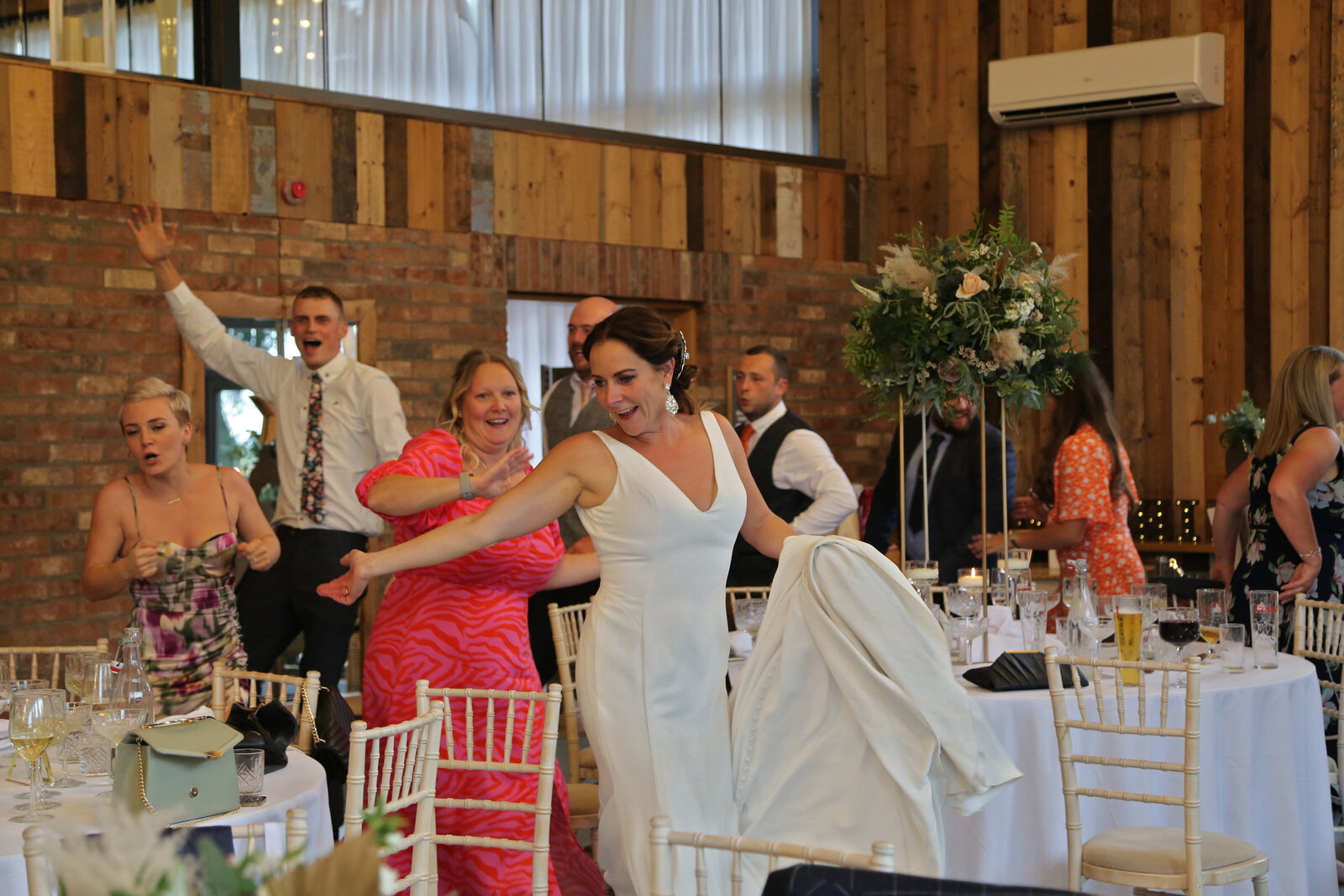 Bride dancing with the singing waiters at a barn wedding