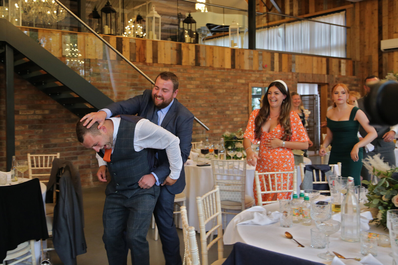 Singing waiter dancing with a guest at a barn wedding