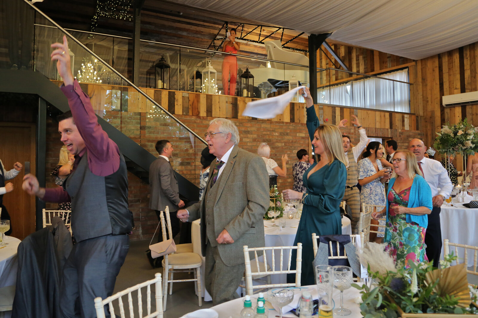Singing waiter dancing through the tables at a barn wedding