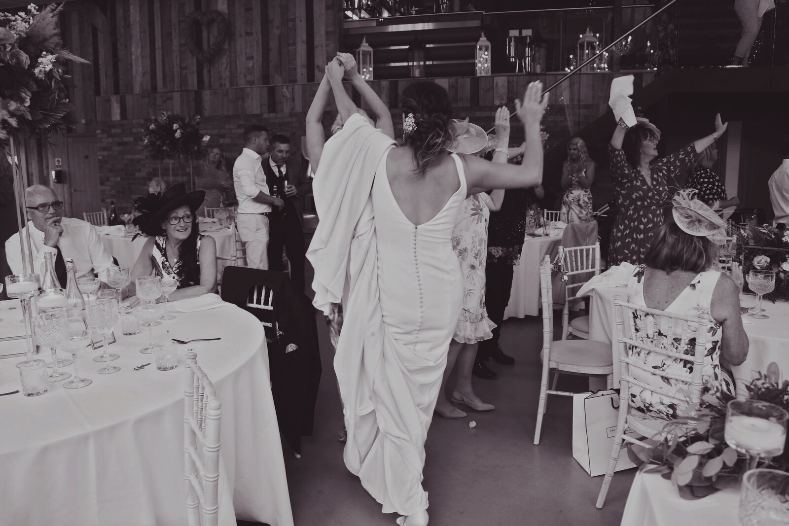 Bride dancing during a singing waiters performance, black and white