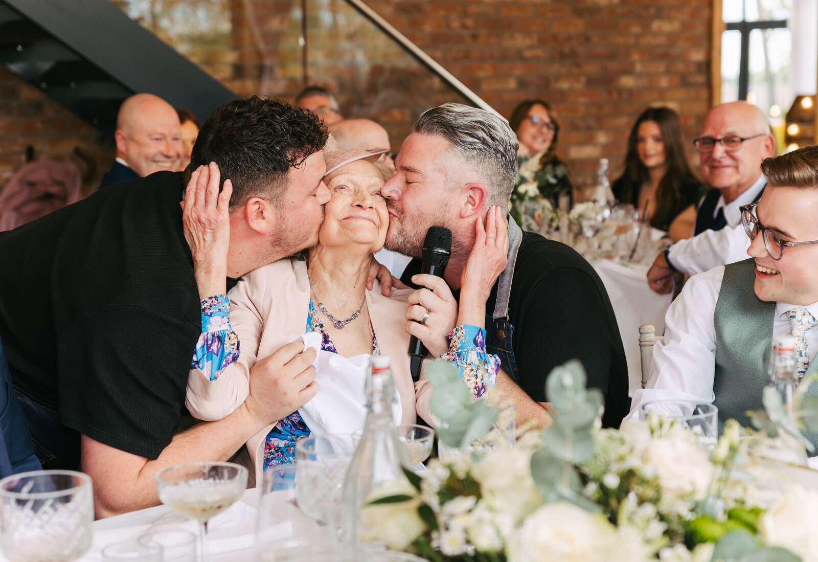 Two singing waiters serenading a delighted wedding guest