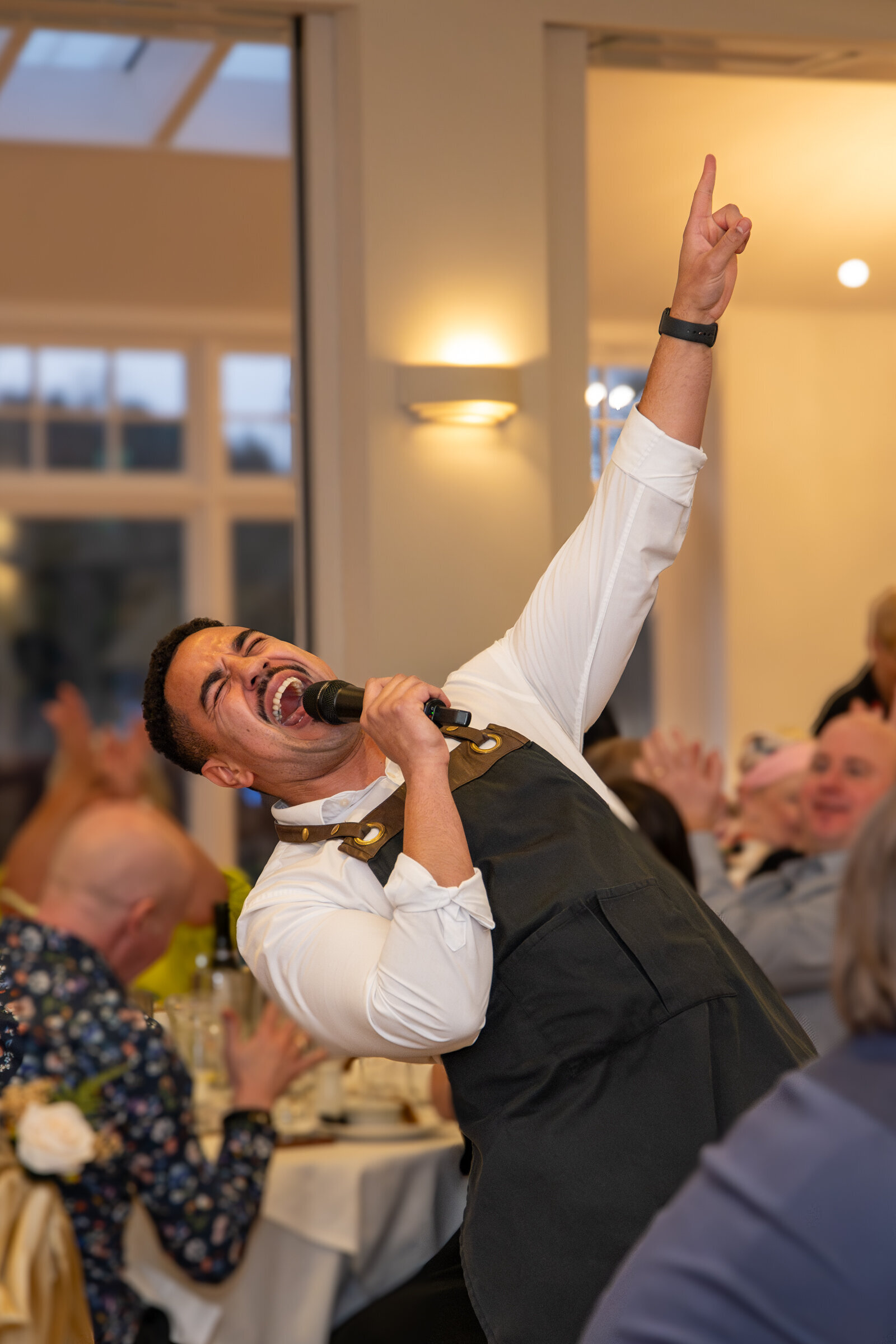 Singing waiter hitting a big note in front of wedding guests