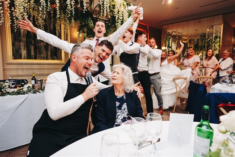 Singing waiters celebrating with guests at a wedding reception