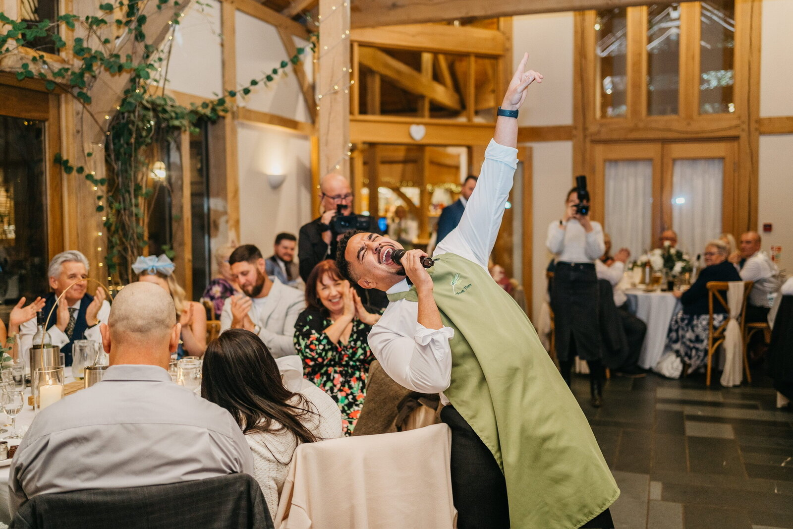 Singing waiters performing to a packed barn wedding reception