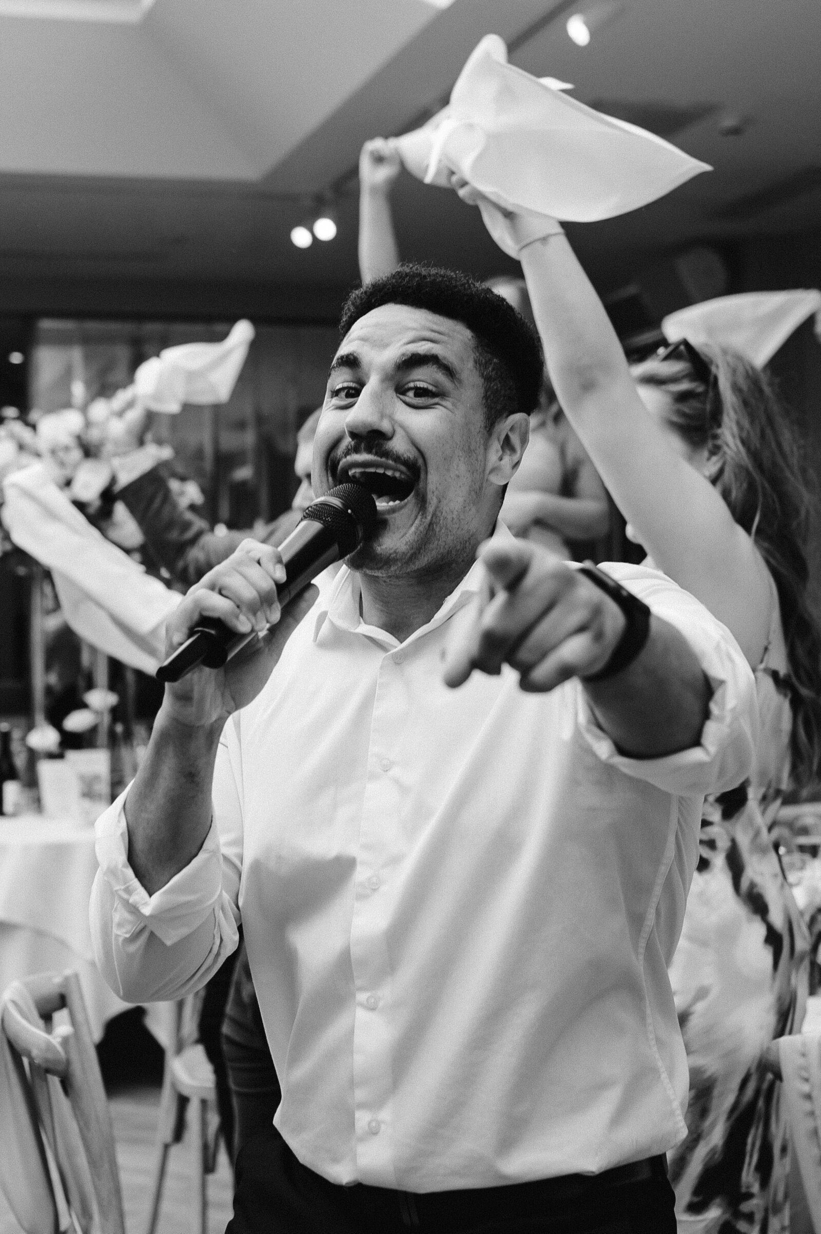 Singing waiter pointing to the crowd mid-song