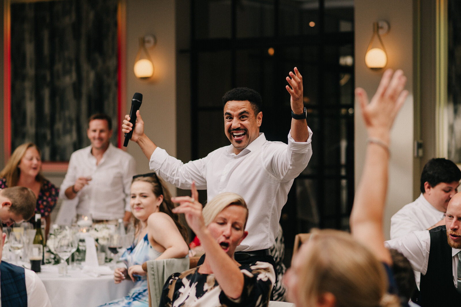 Singing waiters performing as guests raise their arms