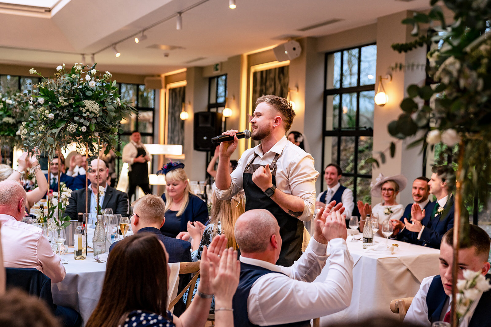 Singing waiters performing to seated guests at a wedding breakfast
